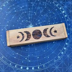 a wooden box with three phases of the moon on it sitting on a blue background