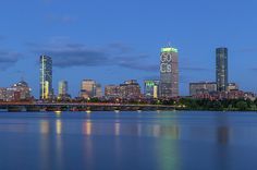 the city is lit up at night and reflecting in the water with its lights on