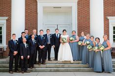 a bride and groom with their bridal party in front of the church door at this wedding