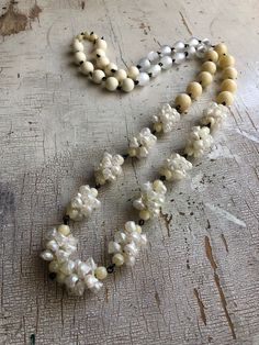 Ivory toned beaded necklace in a long Bohemian rope style, loaded with seashels & other fun cream toned beads. Beads are linked by hand with black wire chain. Necklace measures 41-44" in length & can be worn long and lean or doubled for a shorter statement look. A great versatile style. Made with lucite from 1960's deadstock, from a warehouse that closed in the early 1980's. White Multi-strand Wooden Beaded Necklaces, White Multi-strand Beaded Necklace With Wooden Beads, White Multi-strand Necklace With Wooden Beads, White Double Strand Beaded Necklace, Bohemian Cream Jewelry With Wooden Beads, White Multi-strand Pearl Beaded Necklaces, Cream Pearl Single Strand Beaded Necklace, Cream Beaded Necklace With Round Beads, White Beaded Chain Lariat Necklace