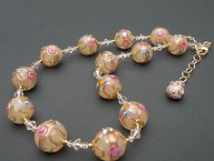 For the Bride, or Mother of the Bride:  Vintage Avorio Murano glass, with 14mm round, Fiorato Italian beads.  These handmade, lamp worked beads were made in Venice / Murano, Italy.   They are round, 14mm Fiorato beads, often referred to in the USA, as "wedding cake" beads, but, Italians have named these beads "Fiorato", flowered beads, and I have been to Venice, Italy over 45 times, and they are always called Fiorato beads. I made this necklace 16 1/2 inches, adjustable to 18 1/2 inches with gold filled link chain, and large, lobster style, spring clasp. Necklace is accented with two sizes of faceted crystals, and small, gold metallic seed beads. Formal Clear Round Beaded Jewelry, Clear Glass Necklaces For Wedding, Elegant Large Beads Clear Jewelry, Elegant Large Beaded Clear Jewelry, Elegant Clear Jewelry With Large Beads, Elegant Single Strand Murano Glass Jewelry, Elegant Necklace With Large Czech Glass Beads, Elegant Single Strand Czech Glass Jewelry, Formal Glass Beaded Necklace