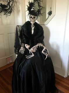 a skeleton dressed up in a black dress