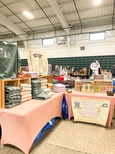 tables with cloths and other items on them in a warehouse or office building for sale