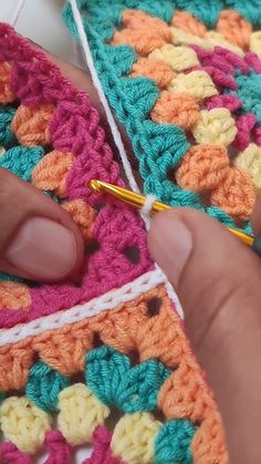 someone is crocheting together with yarn in their hands and they are working on something