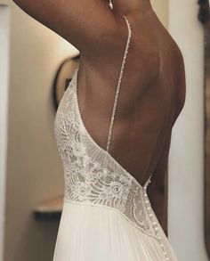 the back of a woman's wedding dress, with her hand on her head