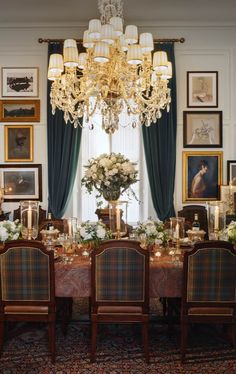 a formal dining room with chandelier and pictures on the wall behind the table