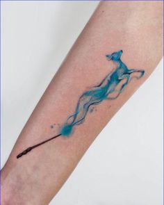 a watercolor tattoo on the arm of a woman with a wand in her hand