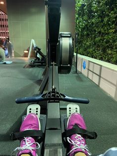 someone is riding an exercise machine with their feet in the air and wearing pink shoes