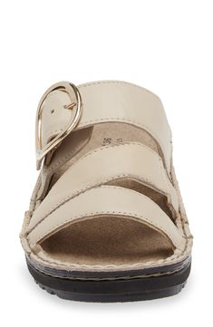 An oversized buckle shines at the vamp of a strappy leather sandal designed with foam cushioning and superior arch support. 1 3/4" heel (size 39) Removable insole Cushioned footbed with arch support Leather upper and lining/synthetic sole Imported Cream Leather Sandals, Cream Sandals With Buckle Closure And Round Toe, Cream Round Toe Sandals With Buckle Closure, Cream Leather Sandals With Low Heel, Closed Toe Beige Sandals With Buckle Closure, Beige Closed Toe Sandals With Buckle Closure, Beige Open Toe Wedge Sandals With Buckle, Cream Closed Toe Sandals With Buckle Closure, Beige Adjustable Wedge Sandals With Buckle Closure