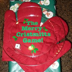 the merry cristmas plate is sitting on top of some wrapping paper and red mitts