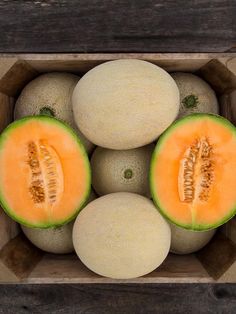 a group of melons sitting in a wooden box