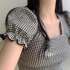 a woman wearing a black and white checkered dress