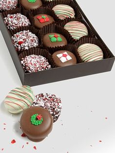 a box filled with chocolate covered strawberries next to a pile of candy canes