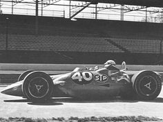 an old photo of a man driving a race car