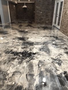 the floor is covered in black and white marble, with a brick wall behind it