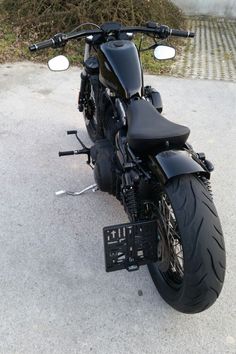 a black motorcycle parked on top of a parking lot