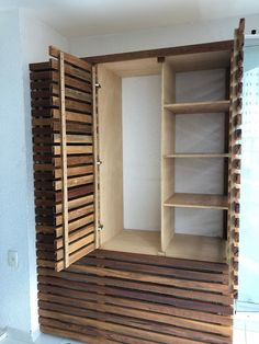 an empty wooden closet with shelves and drawers in the corner, next to a tiled floor