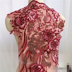 the back of a woman's dress with red flowers and sequins on it