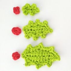 three crocheted pieces of green and red on a white surface