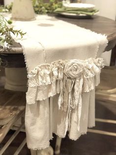 the table is covered with white linens and flowers