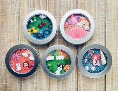 four tins filled with different types of candies on top of a wooden table