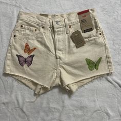 Brand New With Tags Levi’s 501 High Waisted Butterfly Graphic Denim Shorts In A Cream Color With Purple, Green, Orange, And Blue Butterflies Waist- 14” Rise- 10” Inseam- 2” Length- 12” Blue Butterflies, Butterfly Graphic, Levi’s 501, Levi Shorts, Blue Butterfly, Purple Green, Green Orange, Cream Color, Jean Shorts