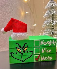 a green box with a grin face on it and a red santa hat sitting on top of it