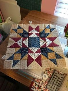 a quilted table topper sitting on top of a wooden table