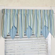 a blue and green striped window valance hanging from a window sill in front of a window