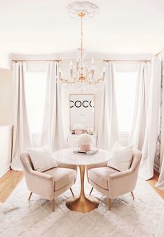 a dining room with two chairs and a chandelier