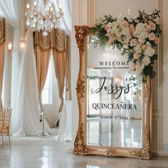 an ornate mirror with flowers on it in front of a chandelier and chairs