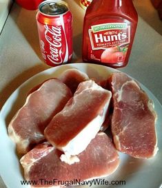 raw meat on a white plate next to cans of hunt's tomato juice and ketchup