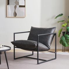 a living room with a chair, table and potted plant