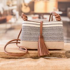 a brown and white purse sitting on top of a wooden table