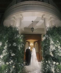 a bride and groom are standing in front of the door to their wedding ceremony venue