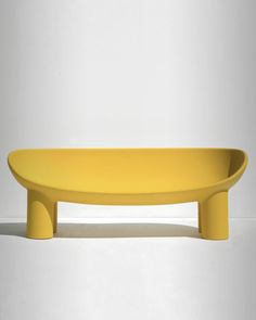 a yellow bench sitting on top of a white floor