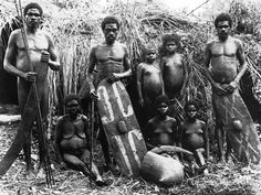 an old black and white photo of men standing next to each other in the grass