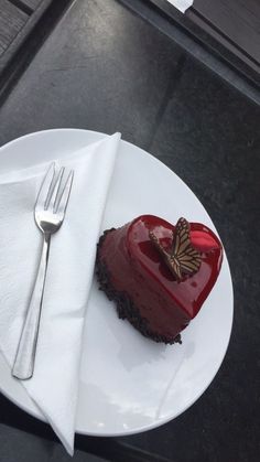 a heart shaped piece of cake on a plate with a fork and knife next to it