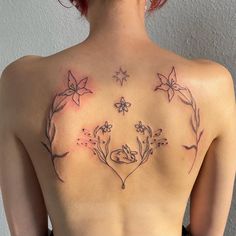 a woman's back with flowers and stars on it