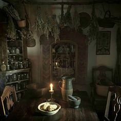 an old fashioned dining room with a candle on the table and dishes in front of it