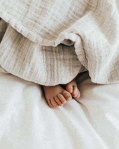 a baby's feet under the covers of a bed