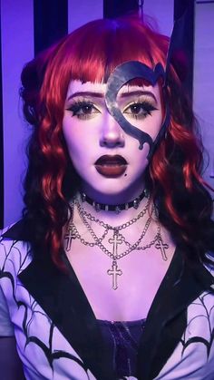 a woman with red hair and makeup is wearing a cross necklace, choker and collar