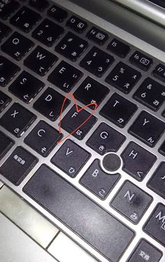 a computer keyboard with a red heart on it