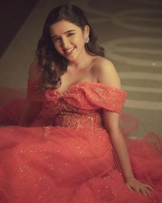 a woman in a red dress sitting on the floor