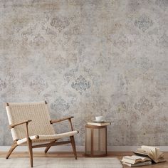 a chair sitting in front of a wall with a book on the floor next to it