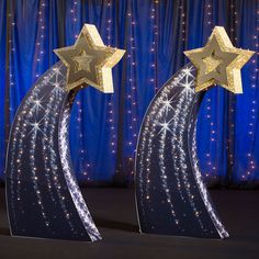 two stars are placed on top of each other in front of blue curtained backdrop