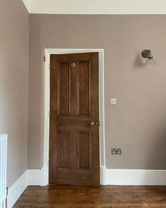 an empty room with a wooden door and radiator