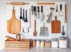 a pegboard with various kitchen utensils hanging on it