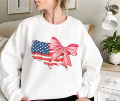 Bow 4th Of July Sweatshirt, USA Sweatshirt, America Sweatshirt, Flag Sweatshirt, Bow Sweatshirt, Independence Day, Gift For Her If you are looking for soft, comfortable, premium sweatshirts and hoodies you are in the right place! A B O U T   O U R   P R O D U C T S *Hoodie -Adult unisex sizing,  -Tear away label,  -Ribbed collar,  -Cuffs and waistband with spandex,  -Pouch pocket, double-blend hoodie with matching drawstring  -Mid-weight 8.0 oz. -50% cotton, 50% polyester -Heather sport colors a White Crew Neck Sweatshirt For 4th Of July, White Long Sleeve Tops For Independence Day, Patriotic White Cotton Sweatshirt, White Long Sleeve T-shirt For 4th Of July, White Long Sleeve T-shirt For Independence Day, America Sweatshirt, Bow Sweatshirt, Independence Day Gift, Usa Sweatshirt