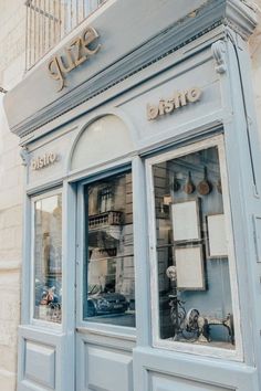 a blue store front with lots of windows and signs on the side of it's doors